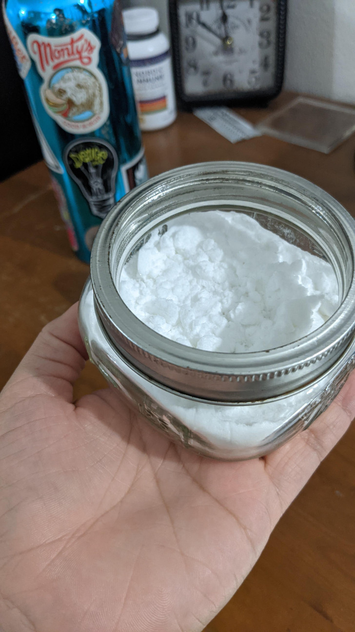 A glass jar filled with powdered detergent