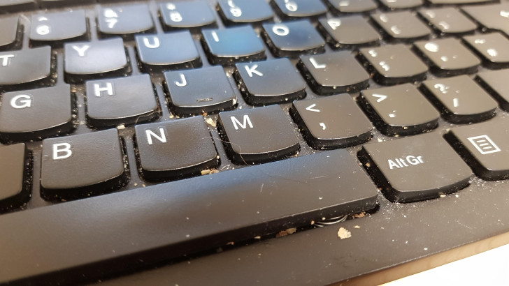 Una tastiera di computer sporca di briciole