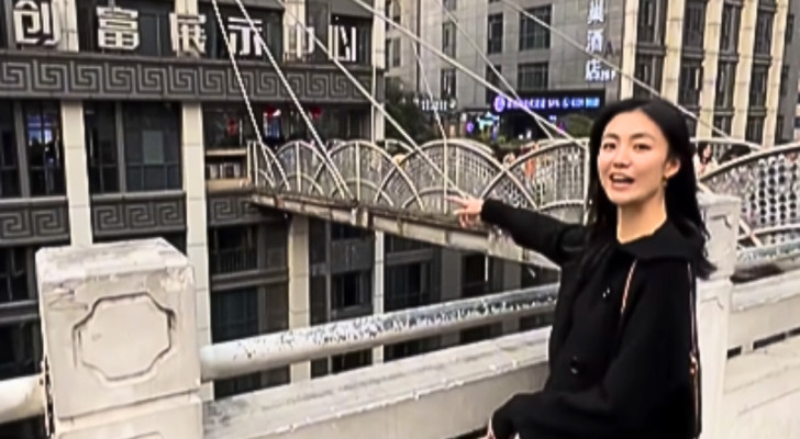 Det ser ut som ett torg , men hon står på taket till en skyskrapa i Kina