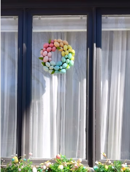 ghirlanda di uova colorate appesa a una finestra