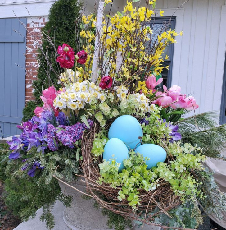 Composizione di fiori e piante primaverili, insieme a uova colorate.