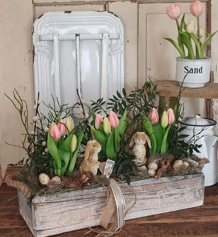 Fioriera con elementi secchi, tulipani freschi e coniglietti decorativi.