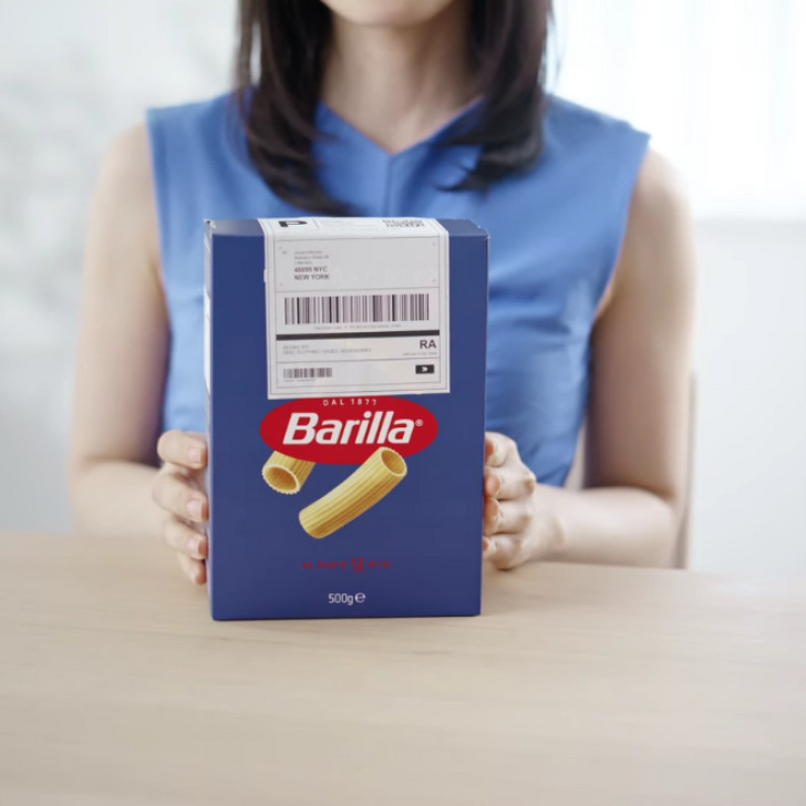 a woman displays a box of pasta