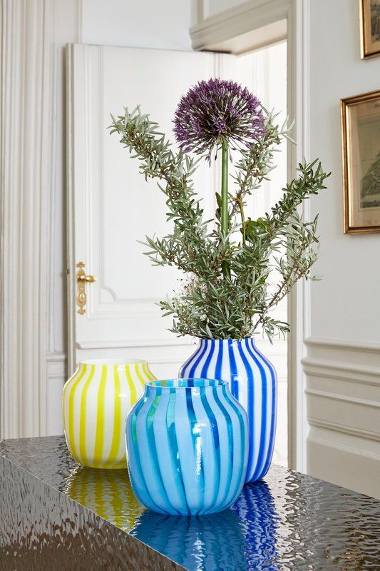 Three similarly-styled, decorative vases on a table