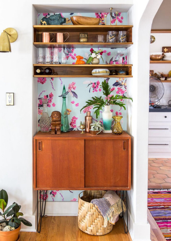 A niche lined with floral wallpaper and equipped with shelves