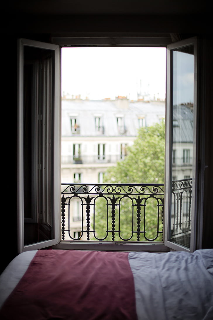 finestra aperta in una camera da letto con vista sulla città