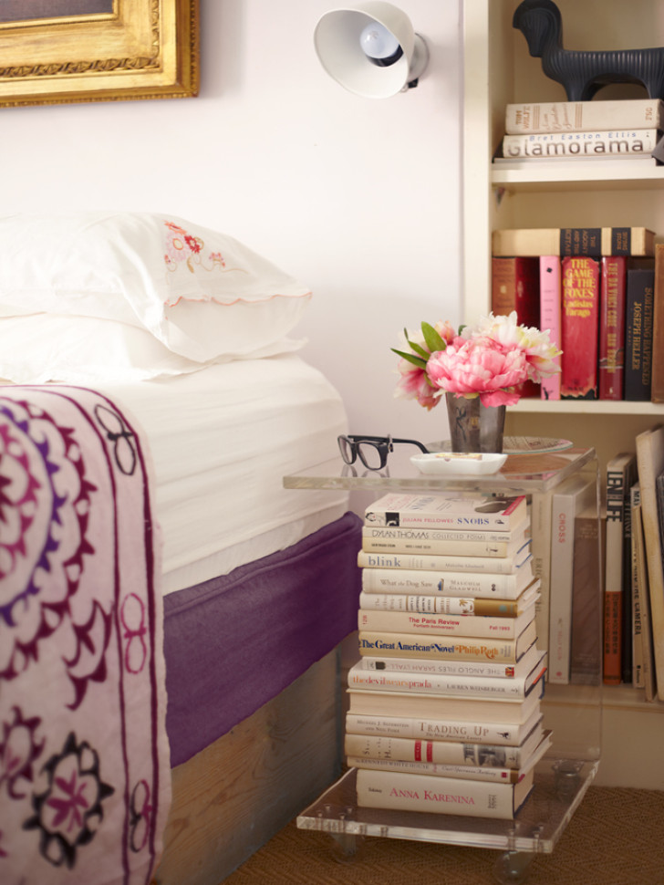 A pile of books transformed into a bedside table using plexiglass