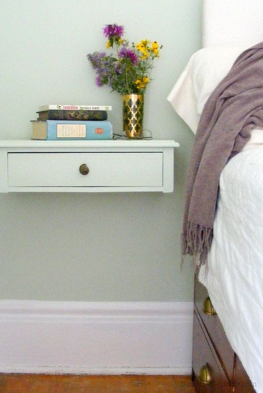 Drawer mounted on a wall next to a bed