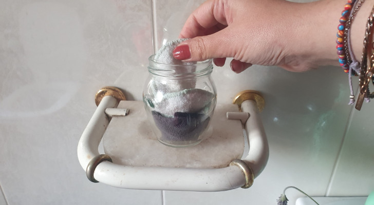 A wet-wipe to remove make-up being taken from a glass jar