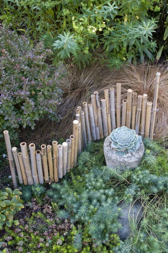 a small flowerbed fence made from bamboo