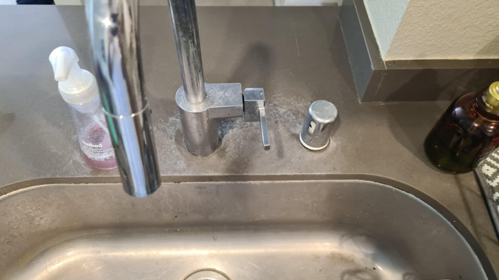 Limescale deposits on a stainless steel sink in a kitchen