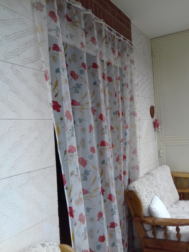 a mosquito net with a floral pattern in front of a French door