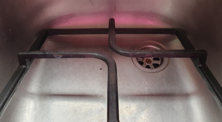una griglia dei fornelli poggiata nella vasca di un lavandino