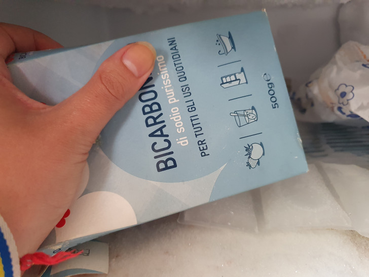 un paquet de bicarbonate de soude placé sur une étagère du congélateur