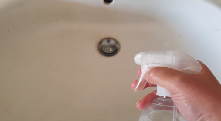 spraying a sink with a spray bottle