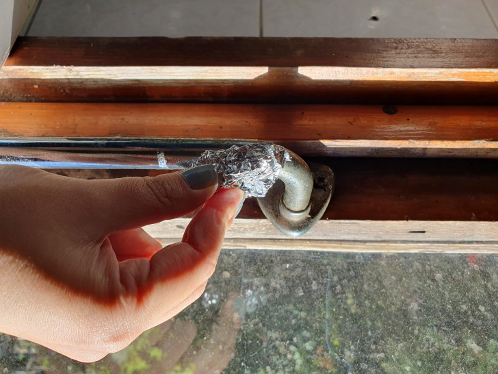 rubbing a ball of aluminum foil on a rusty, iron handle