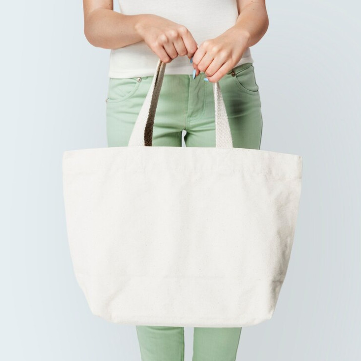 une femme tenant un tote bag blanc