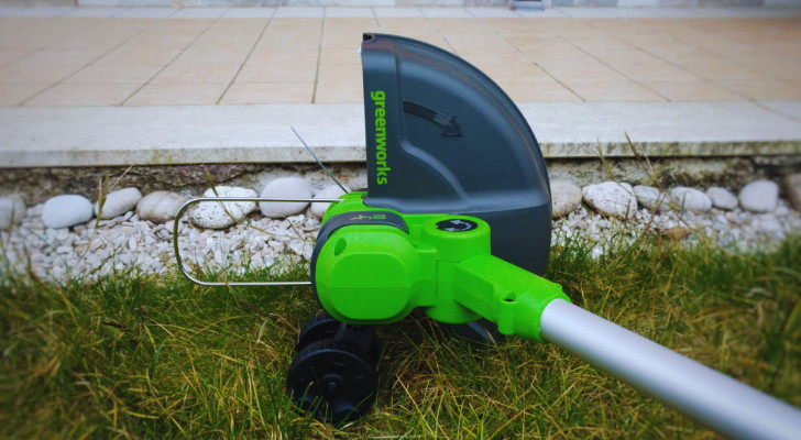 a brush cutter resting on a cut lawn