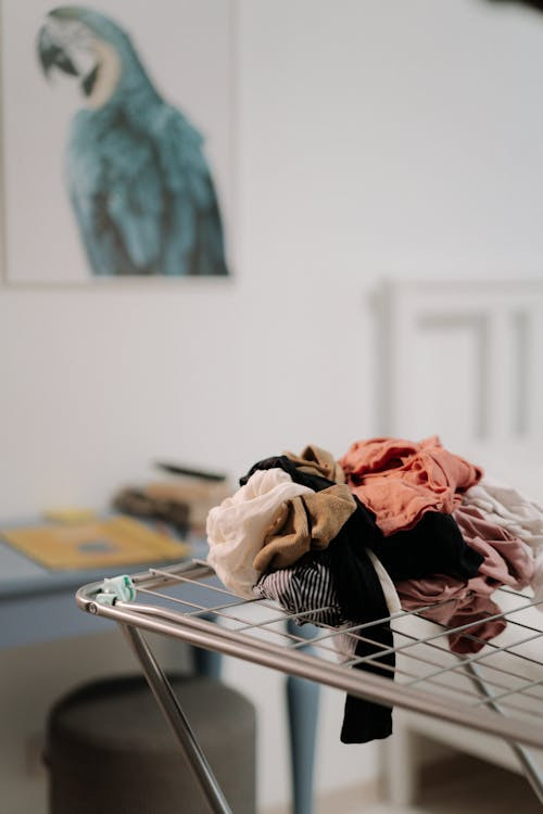 a pile of clothes on a clothes horse indoors