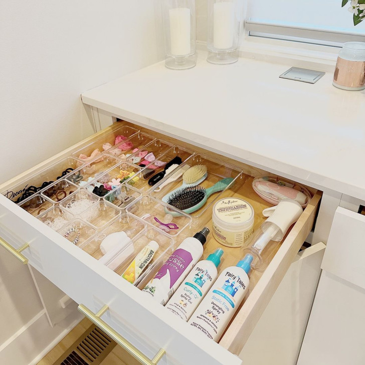 A perfectly organized drawer with dividers that contain various bathroom accessories