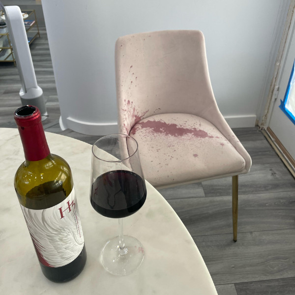 A large red wine stain on a fabric-covered armchair