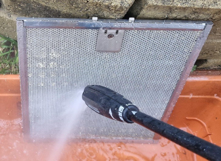 Cleaning the extractor hood filters with a pressure washer