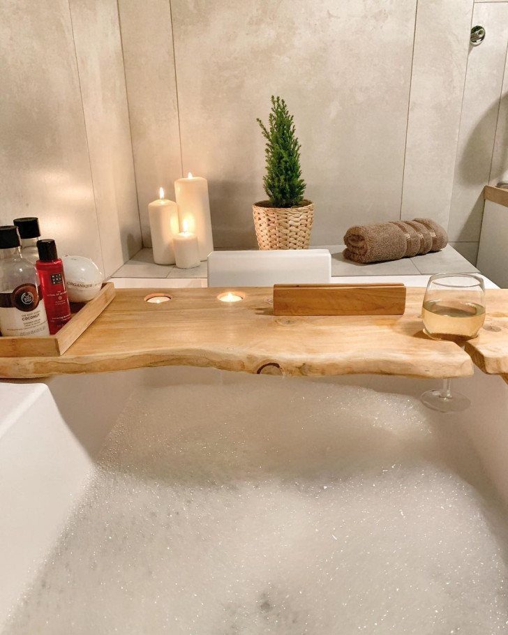 A cozy bathtub with a warm, wood bath caddy