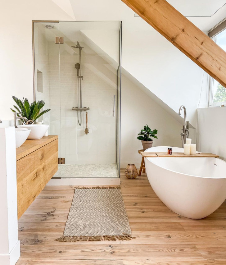 A bright, warm bathroom with parquet flooring and exposed, ceiling support beams