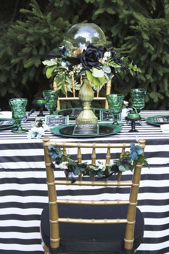 A table decorated for Halloween in shades of green, white and black