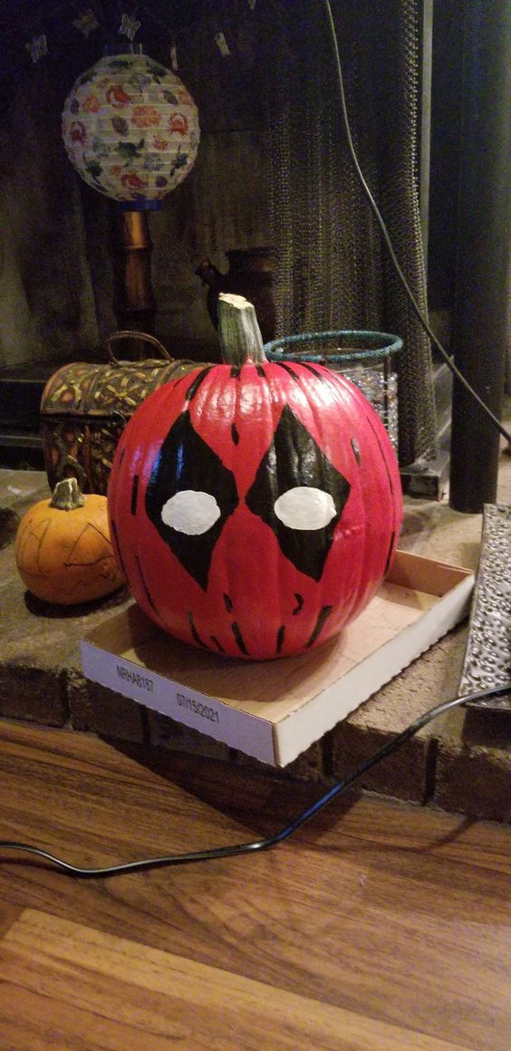 A Halloween pumpkin painted to look like Deadpool's mask