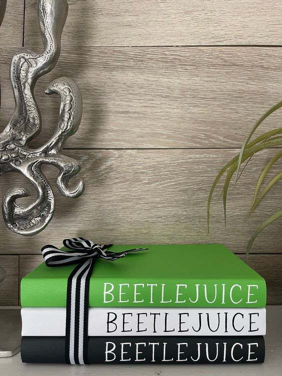 Stapel von drei Büchern zur Dekoration des Hauses mit dem Titel Beetlejuice auf dem Buchrücken