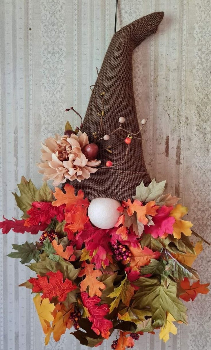 A decorative gnome made from fabric and autumnal leaves