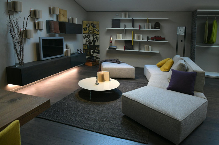 A well-furnished living room with shelving on a previously empty wall