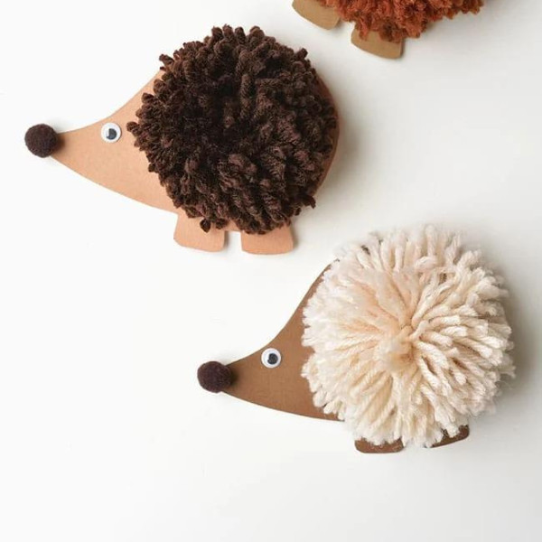 Small pom-pom hedgehogs made from cardboard and wool