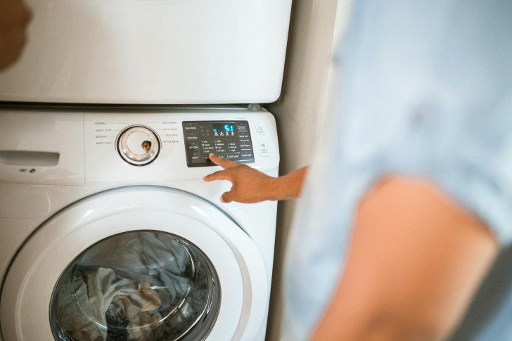 Une personne utilise une machine à laver pleine