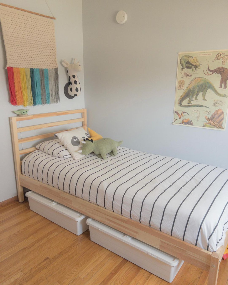 A child's bed with plastic, under-bed boxes