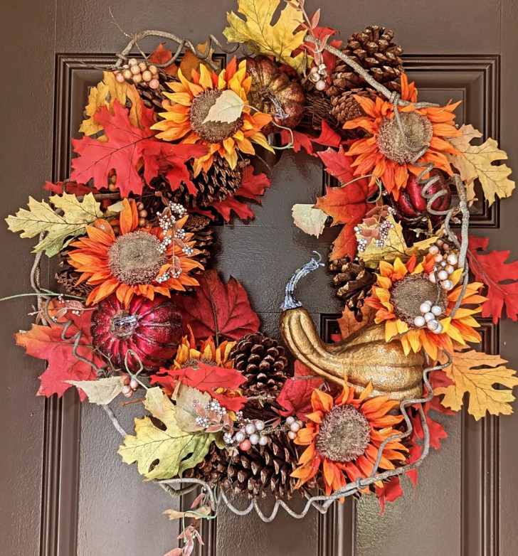 Wreath with maple leaves, pine cones and sunflowers