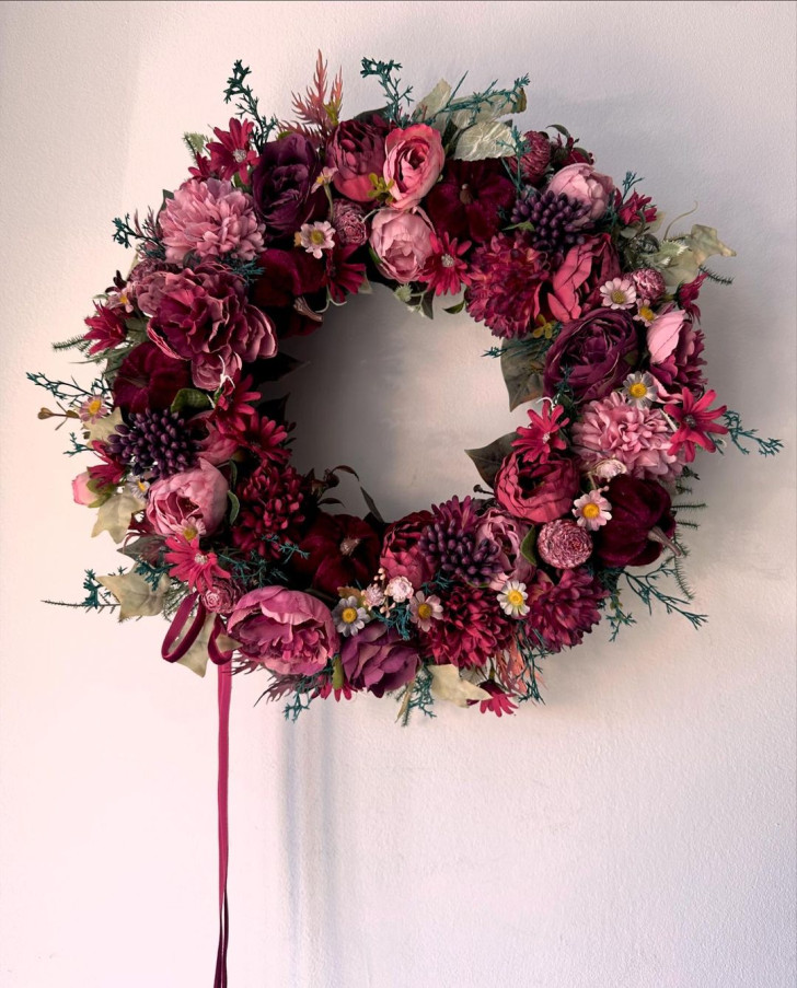 Wreath with burgundy colored flowers and leaves