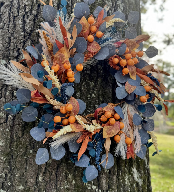 Krans met blauwe bladeren en oranje fruit