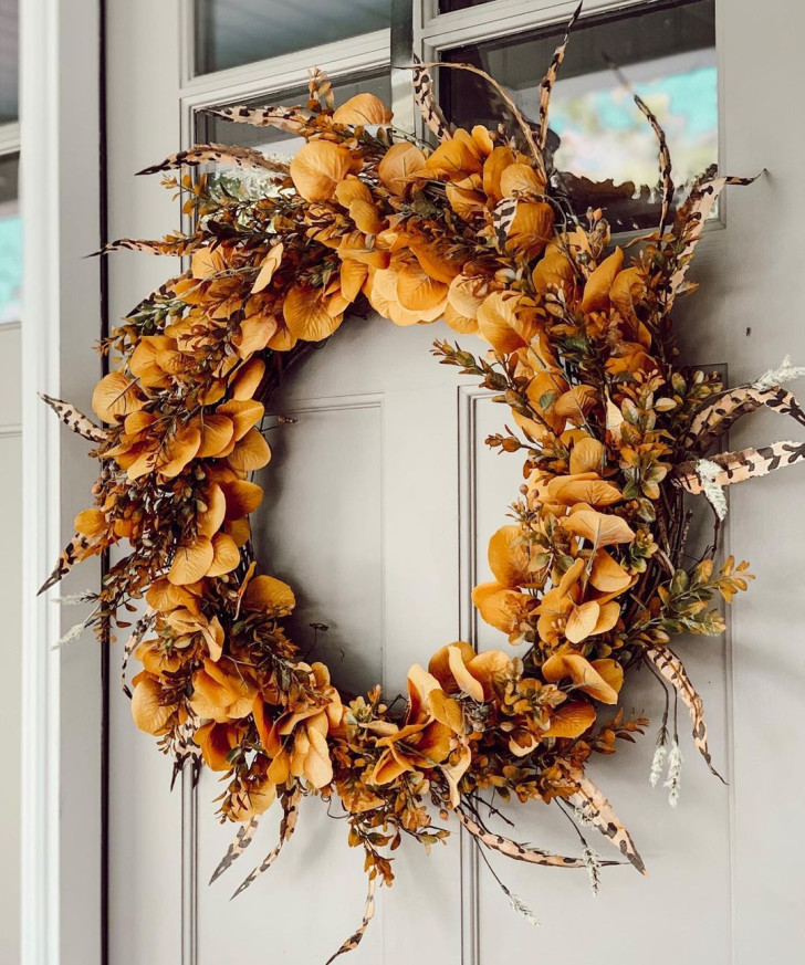 Wreath with golden-yellow leaves and feathers