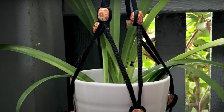 A hanging planter made from shoelaces