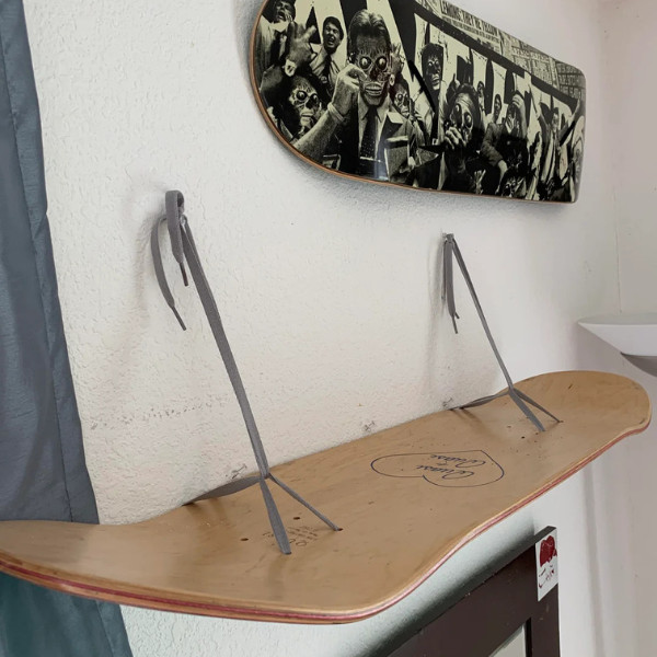 A shelf made from a skateboard and shoelaces