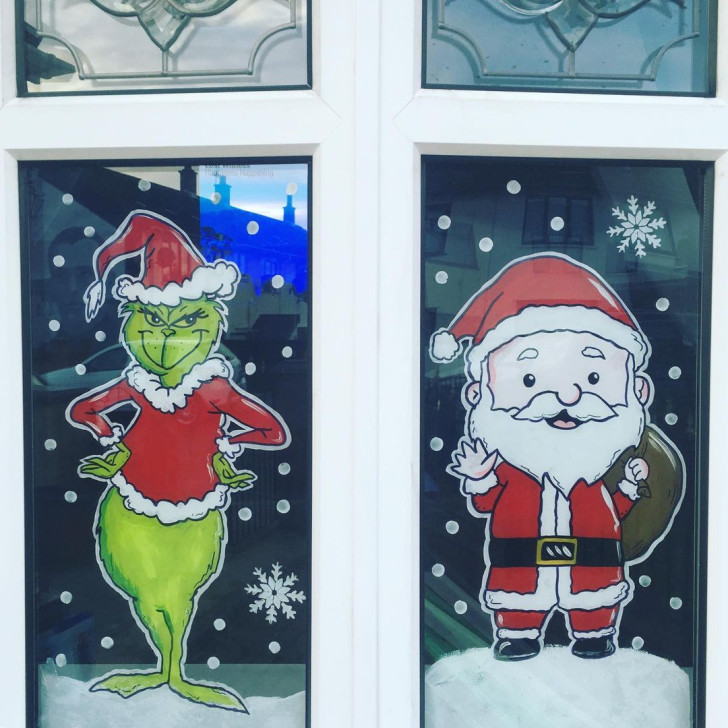 Grinch e Babbo Natale disegnati a colori su una finestra