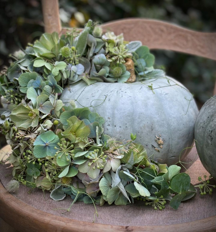 a silver-skinned pumpkin decorated with hydrangea flowers in a similar shade