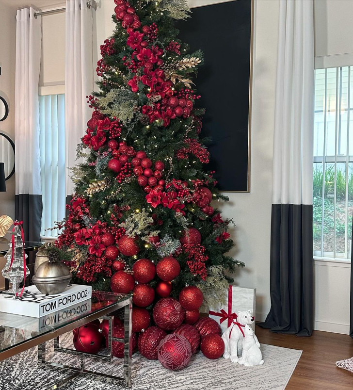 a Christmas tree decorated with red ball ornaments of various sizes