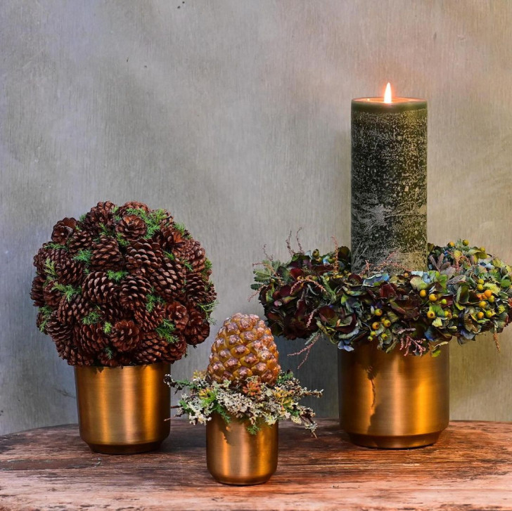 Christmas centerpiece decorations made of wood and pine cones in metal containers