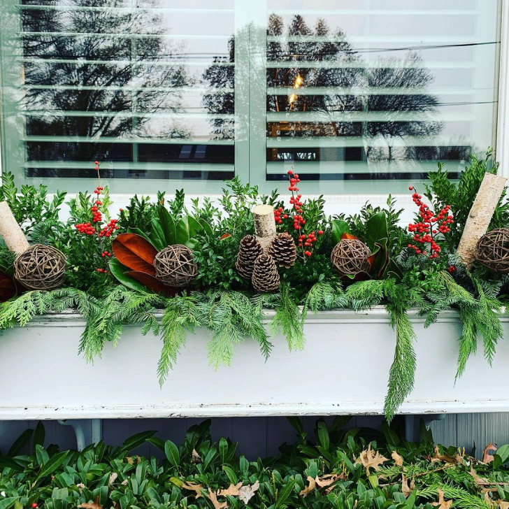 Jardinière pour rebord de fenêtre avec branches de sapin, baies, pommes de pin et boules en osier tressé