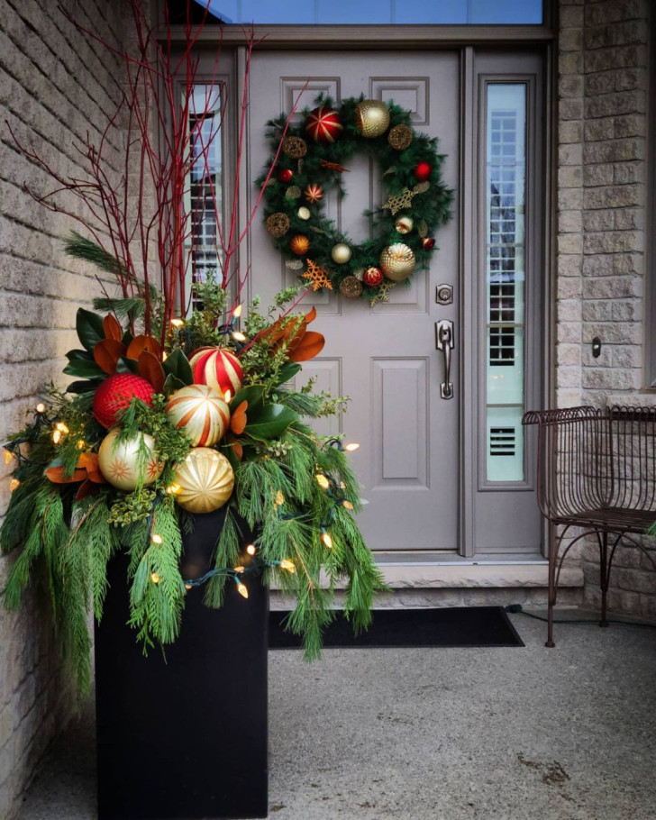 Grande jardinière avec branches de sapin, boules colorées et guirlandes lumineuses