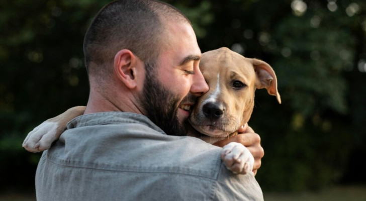 Uomo che prende in braccio un cane