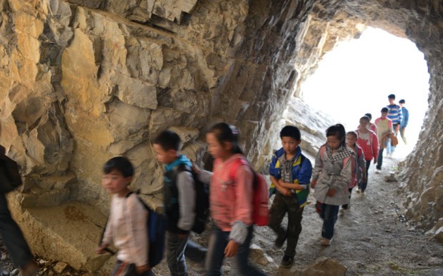 Kinderen lopen achter elkaar in een rij naar school en trotseren elke hoogte!